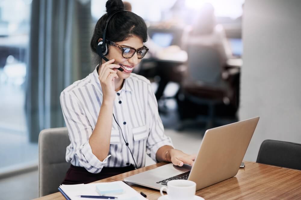 Smiling call center agents speaks to multi-lingual customers.
