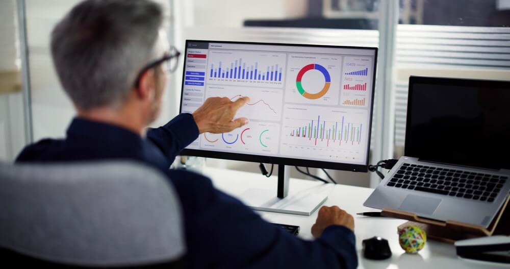 Business Data Analyst Using KPI Data Dashboard on Computer to examine insurance data analytics.